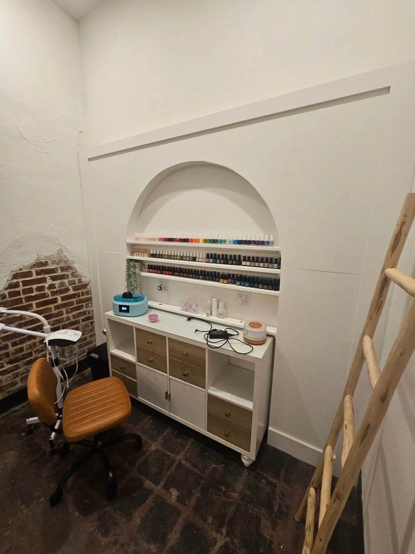 Completed spa manicure station with an arched built-in shelf and polish display