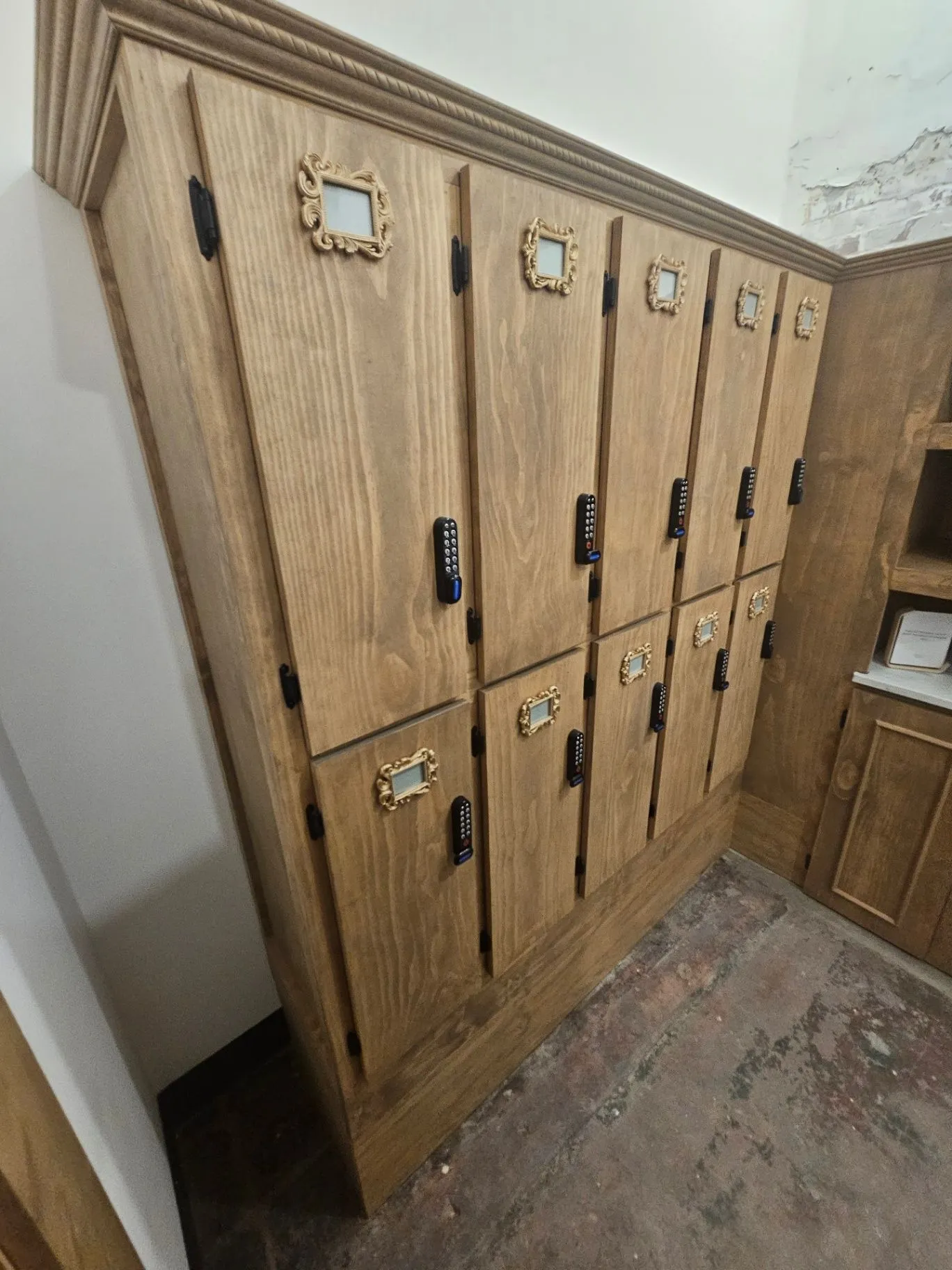 Completed wood locker wall with framed labels and keypad locks