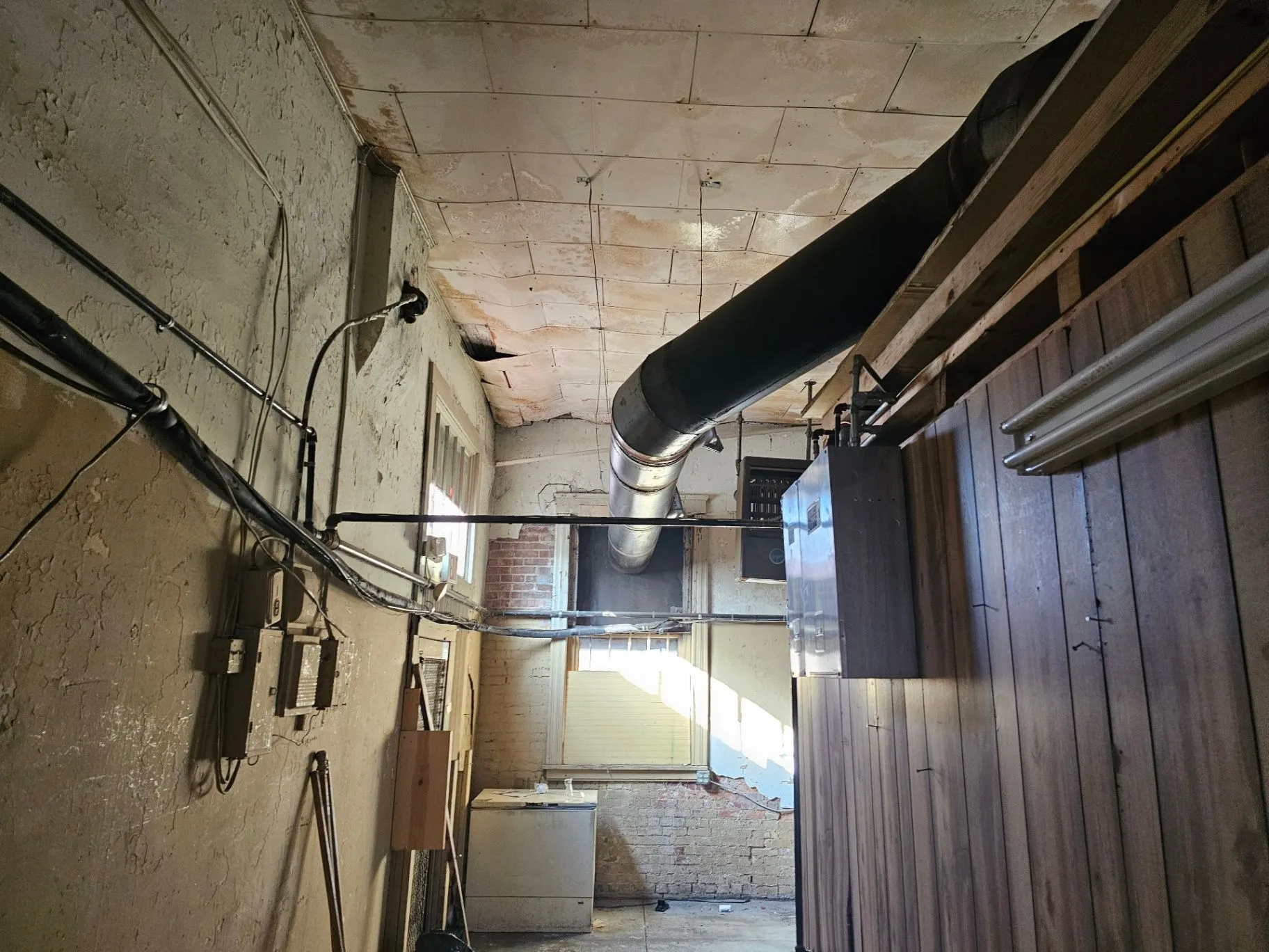 Service corridor with exposed ductwork and unfinished surfaces