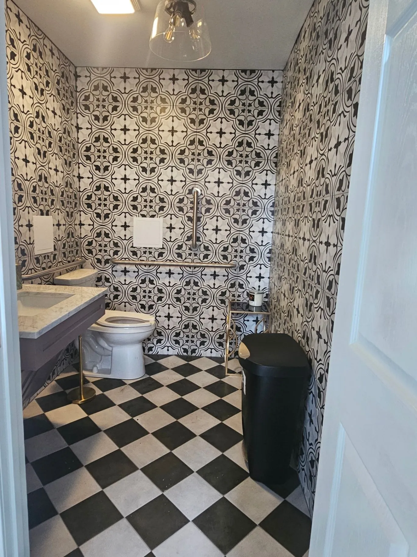 Completed Wine Bar powder room with patterned tile, a vanity, and checkerboard floor