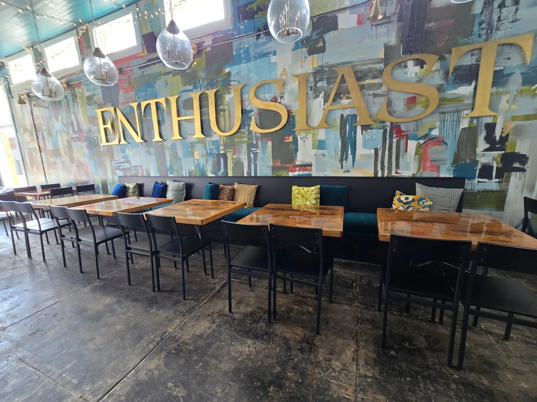 Completed Wine Bar dining room with a colorful mural, pendant lights, and banquette seating